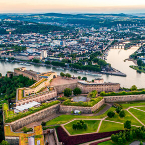 Luftaufnahme über der Festung Ehrenbreitstein mit der Stadt Koblenz und dem Zusammenfluss von Rhein und Mosel im Hintergrund. © 